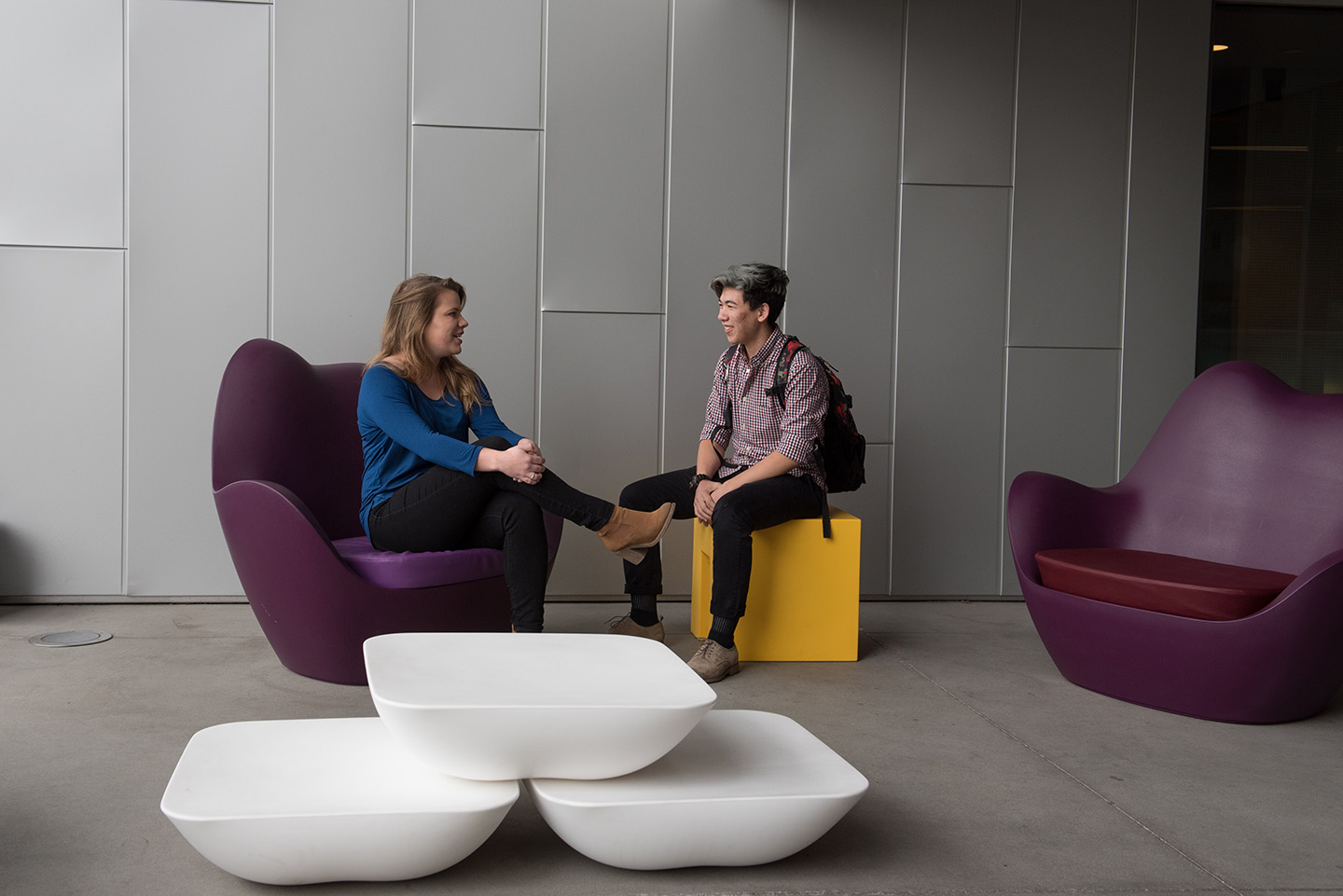 Two students facing each other and talking in common space at Emerson Los Angeles